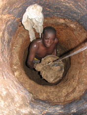A toilet emptier passes the bucket full of faecal sludge to his assistant. The man works without gloves, boots and mask, because these are too expensive. This is an extremely undignified task that poses severe health risks. Source: SuSanA on Flickr (2007)
